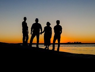 Group of friends standing on a hill at sunset